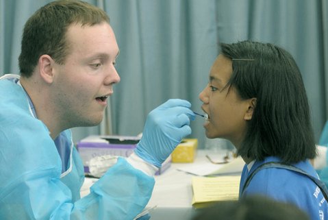 Amazing Grace Llanos gets a fluoride treatment from dental student Charles Woodward Jr.