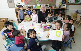 Lorraine Neenan surrounded by the children of Community Action Commission's Los Ninos Center day care.