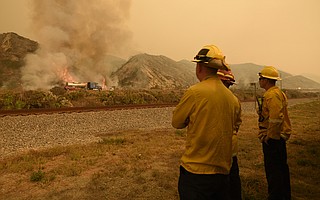 Carpinteria firefighters watch the Thomas Fire burn along Highway 101 in the Faria Beach area on December 6, 2017.
