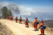 Firefighters from the Prado Conservation Center in San Bernardino prepare to head down a dozer line to set backfire.