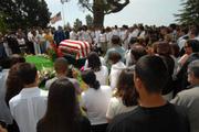With the American flag at half-staff in the background, mourners pay their last respects
to Spc. Jaime Rodriguez Jr. before his burial at Santa Barbara Cemetery.