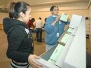 Julie Plaza (left) and Delores Lugo process absentee ballots arriving at the Earl Warren Showgrounds from Santa Barbara North County.
