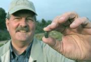 Biodiesel guru Russell Teall holds a jatropha nut and stands at Santa Barbara County-owned property near
El Sueno Road. The spot isn't suitable for many crops, but jatropha just happens to thrive in so-so soil, even without the amount of fertilizer many other biofuels sources might require.