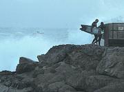 While Harbor Patrol makes the rounds, surfers time the waves, waiting for a chance to jump in at Sandspit.