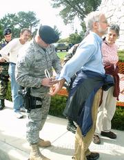 Larry Purcell (far left), Ed Ehmke, and Mary Jane Parrine are taken into custody by Vandenberg security after refusing to leave the base.