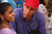 Vitamin Angels' founder Howard Schiffer speaks with a mother at a vitamin distribution in the slums of Pune, where more than half of the city's 2.5 million people live in more than 500 slums.