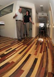 EDC Executive Director David Landecker (left) and Chief Council Linda Krop display the office's new flooring made from local wood