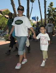 "My mom is not a criminal" states the shirt of 4 year-old Angel Quinone (right) walking with mom Alisha Dally