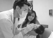 Clinic assistant Jesus Casillas administers an oral vaccine to a two-month-old baby at the Westside Neighborhood Clinic.