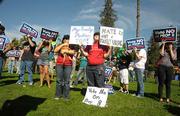 Jen Cook (center) holds signs ion protest of Prop 8 and a shirt that reads "here come the brides"