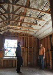 Nick Chatwatanasiri (left) and Glen Deisler check out the sustainable insulation, during groundbreaking ceremonies for Victoria Garden Mews.