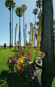 The sculpture donated by artist Morris Bear Squire a cactus plant with seventeen unique flowers, marked with the names of the deceased, along with one of the deceased pet Max a German shepherd