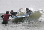 L to R surf instructor JP Garcia steadies Miguel's and Andres's boards holding out for a better wave for them to ride.