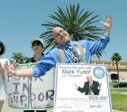 KCSB's Bryan Brown emulates the shoulder-shrugging photo of Mark Yudof on his protest sign that points out the disparity of pay in a time of budget cuts