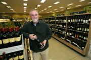 General Manager John Jurey holds a bottle of Consilience 2006 Pinot Noir, one of the many local labels in Whole Foods wine section.
