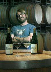 Santa Barbara Winery's Assistant Winemaker Ryan Ralston proudly shows off some red and white selections, both of which were winners with this year's readers.