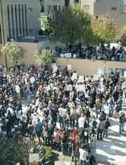 Seen from the third-story meeting room where Regents voted on tuition hikes, students and workers gather in protest at UCLA's Covel Commons.