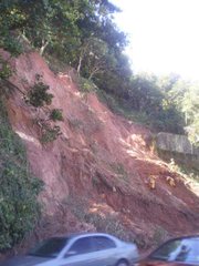 Workers try to repair the electrical wires that were crushed three days earlier in this mudslide along the well-traveled road of Niemeyer. These cars would have been crushed, had the road not been closed for the better part of the week.