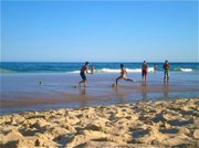 Some Carioca guys spend the afternoon playing futebol on the beach, using two coconut shells to create a goal in the wet sand.