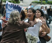A driver, fed up with waiting at the blocked intersection of State and Anapumu Streets, shouts "Just move!" while nudging one of the protesters blocking traffic.