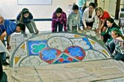 Emiliano Avila, Victoria Gutierrez, Kiera Carrillo, Juan Esleta, Alyssa Dominguez, Morgan C., Celina Rivera, and Ariana Rivera raise a section of <em>One Stone at a Time</em>.