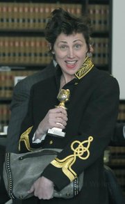 Leaving the courtroom during a hearing in March for the San Ysidro Ranch incident, Evi Quaid mugs for the camera holding up Randy Quaid's 1988 Golden Globe award for his role in LBJ: The Early Years
