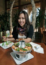 Sanji, an SBCC student from Indonesia, is very happy to have found the Saigon restaurants. Food pictured: tropical Seafod Hot Pork with Shrimp Spring Rolls.