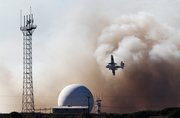 10/28/10 An aerial tanker flies past a tracking station neat Vandenberg Air Force's Solvang Gate while battling the Bear Creek Fire.