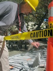 UCSB Design and Construction Manager John Wolever holds up a wire that connected the suspended ceiling to a concrete deck.