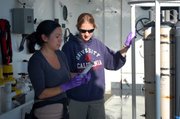 UCSB graduate student Stephanie Mendes, left, and postdoctoral researcher Molly Redmond sampling water