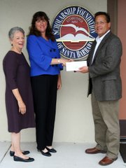 Scholarship Foundation Board Members, Kathy O’Leary and President Patricia MacFarlane, are pleased to accept a gift for scholarships from Frank Betts, ExxonMobil Superintendent.