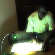 A student in Ghana completes his homework by the light of a solar-powered LED lamp designed at UCSB's Institute for Energy Efficiency