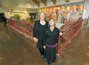 Posing in front of a mural painted in 1984 by the late Channing Peake is his wife Cheri Peake (left) and daughter Tuni Peake during the Santa Barbara Airport remodel grand opening celebration June 17, 2011