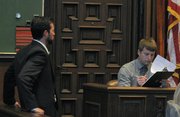 John Page gives samples of his signature on the stand as he's watched by handwriting expert Joseph Merydith