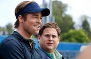 Brad Pitt stars as Oakland A’s general manager Billy Beane opposite Jonah Hill as his number-crunching assistant in the based-on-a-true-story baseball movie <em>Moneyball</em>.