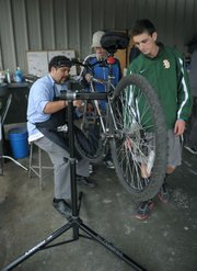 Bici Centro volunteer Eddy Gonzalez (left) and SBHS student Pete Chaconas (right) help Michael Trapani with a bike tune-up.