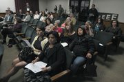 Area residents, including Sergio Romero's mother, Guadalupe Romero (foreground), listen during Thursday's presentation on Milpas Street safety