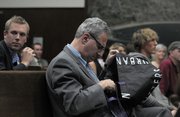 Stephen Jospeh, attorney for the Save the Plastic Bag Coalition, examines a reusable bag from Urban Outfitters