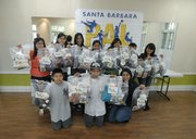 Volunteers show the blankets they created as members of the Police Activities League Knitting Club