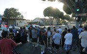 A crowd gathers as police respond to reports of a woman with a handgun barricaded in her Milpas Street apartment