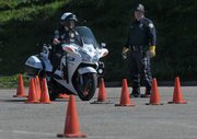 Officer Tiffany Keller navigates a training course at Earl Warren Showgrounds with Jaycee Hunter looking on.