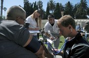 Kona (left) receives treatment from Doctors without Walls led by Dr. Jason Prystowsky (center)