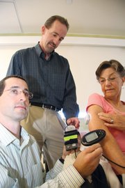 <b>Techno Treatment:</b> UCSB’s Frank Doyle (center) oversees researcher Eyal Dassau (left) analyzing data from the glucose monitor in diabetes patient Sharon Sorenson’s stomach.