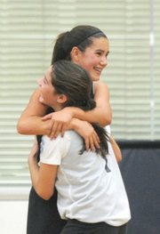 <b>FRIENDLY FOES:</b> Claire Early (left) of the Lynx hugged it out with opponent Morgan Jensen-Magne of the Stars when they accidentally collided while playing a hotly contested basketball game at the Page Youth Center.