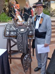 <b>RIDING TALL:</b> This year’s El Presidente, Dennis Rickard, poses with the saddle his grandfather, James Rickard, had made in the 1920s by renowned saddle maker Luis Ortega and master silversmith John Field. Dennis’s father, John “Jack” Rickard, also used this saddle when he rode in the Fiesta Parade as El Presidente in 1948-49.