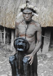 A Lani tribesman shows a mummy of a "big man" who was important in the village. The mummy lives in his own hut and is asked questions of importance by the village when needed. Harris said he only knew of three mummies through out the highlands.
