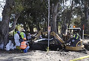 Backhoes do the heavy lifting before the polluted dirt is sifted and sorted