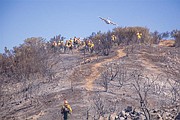 A plane prepares to drop retardant along the east side of the ridge and just over the heads of the crews cutting hand line.
