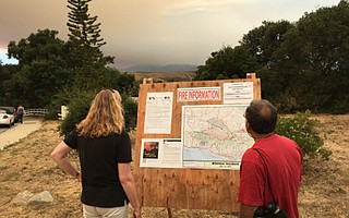 Winchester neighborhood residents check the information boards set up for the Whittier Fire.