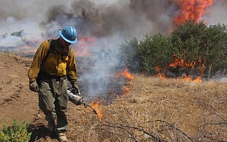 One of the Del Rosa Hot Shot crew out of San Bernardino enlarges the backfires being set to reduce the fuel load.